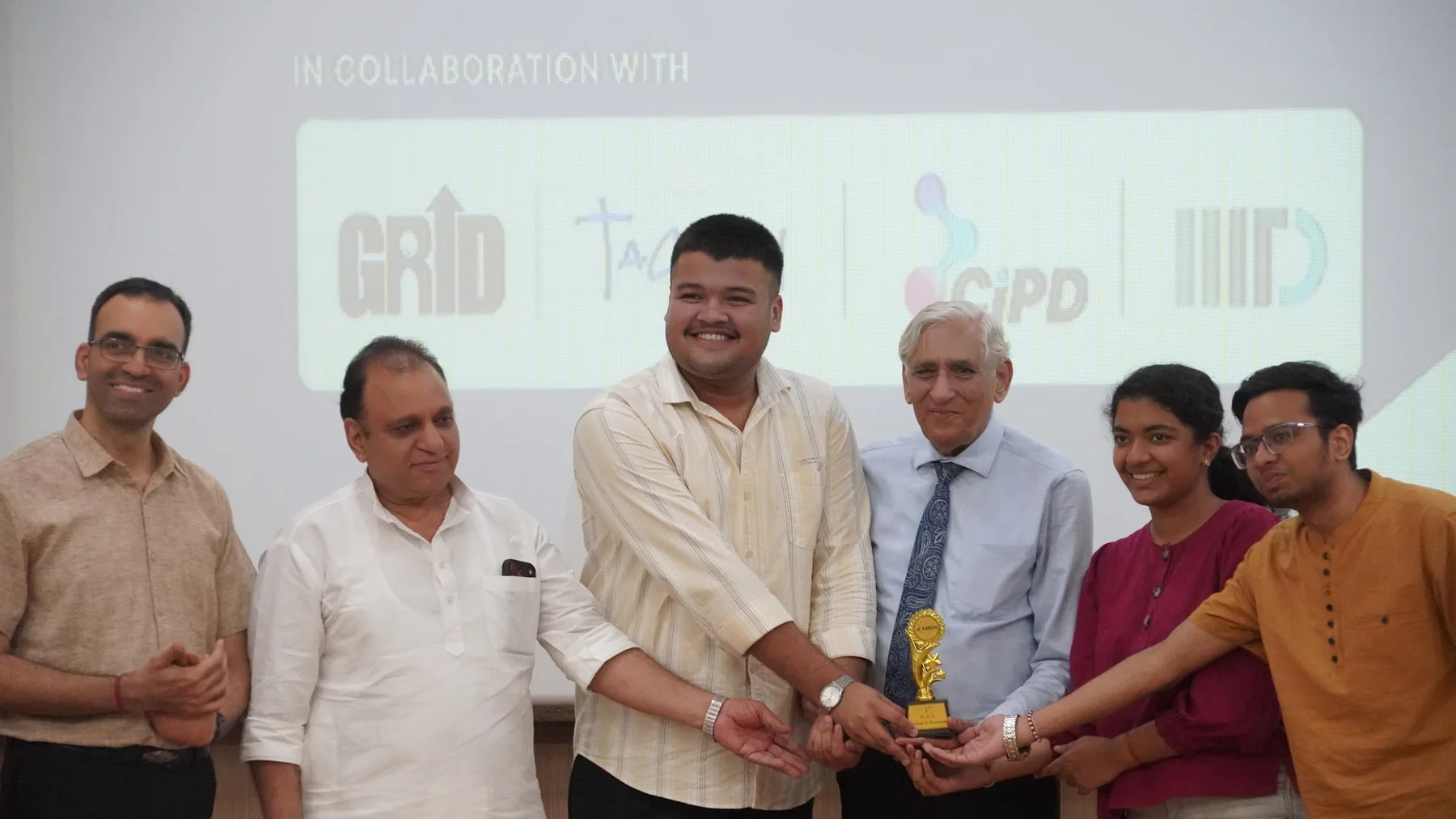 AAROH collaborators and participants holding an award together on stage